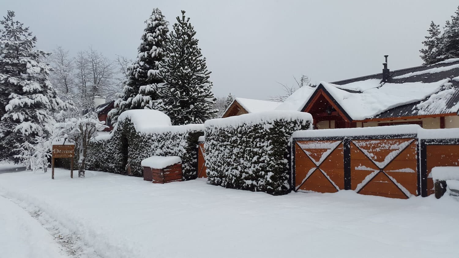 Entrada de las Cabañas Denise vista desde la calle con nieve