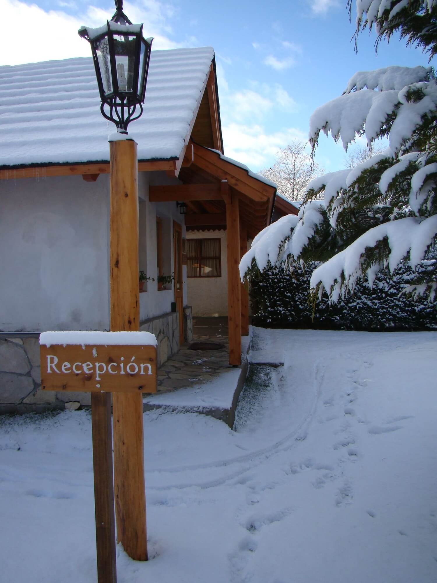 Entrada a la recepción de Cabañas Denise con nieve